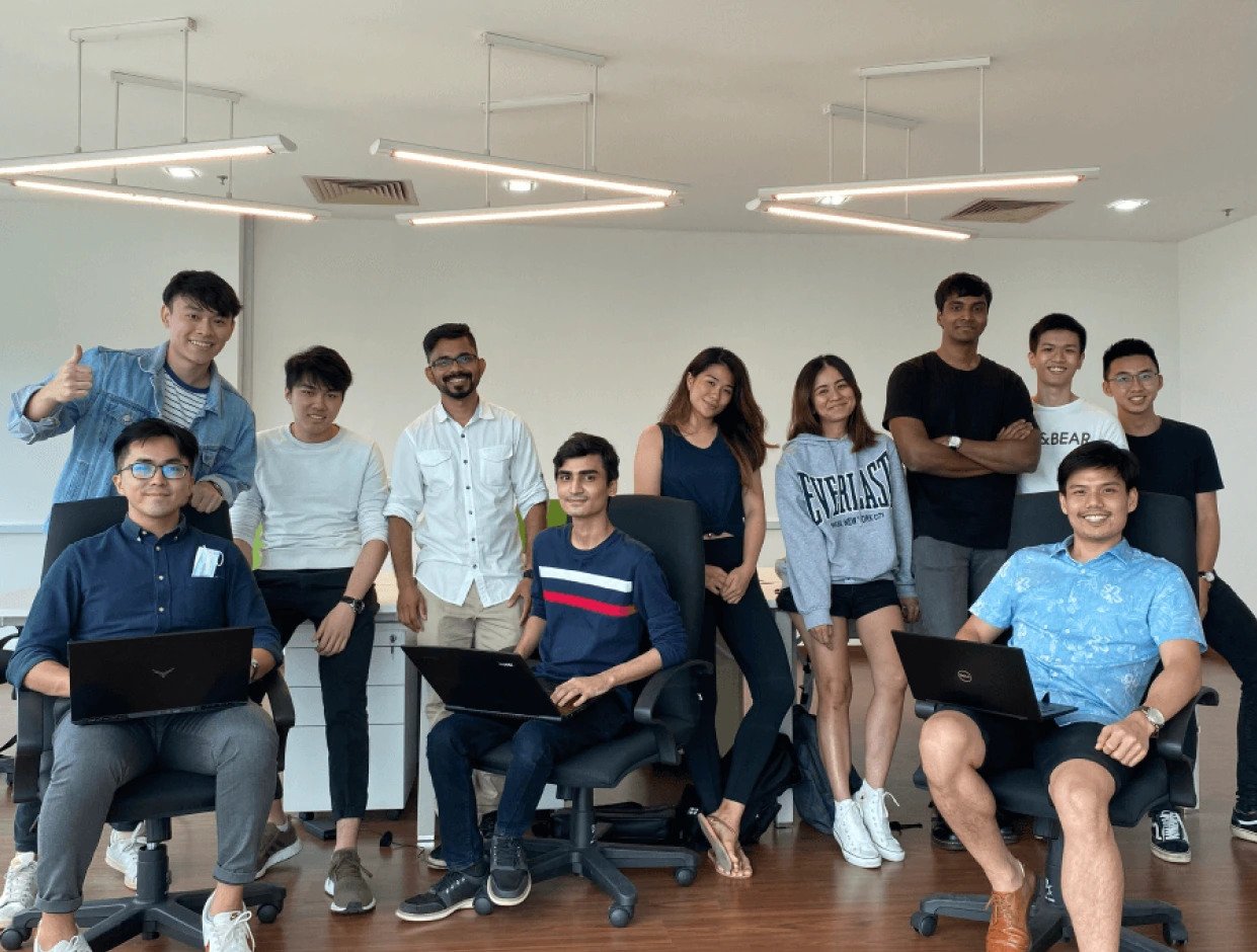 Group of students smiling together in a classroom setting, showcasing the strong sense of community at Sigma School, where collaboration and peer support are key elements of the learning experience